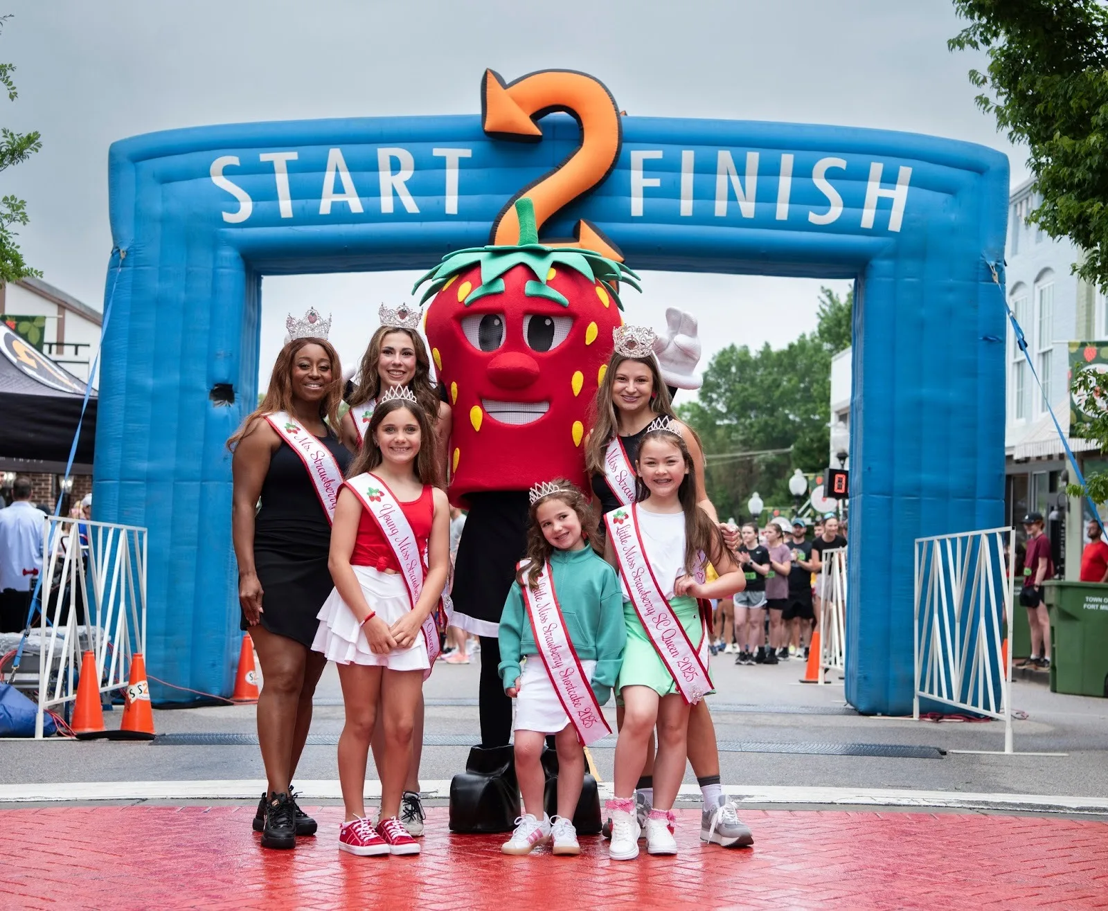 Winners of the Little Miss, Miss, Teen, and Ms. Strawberry Festival Pageant pose at the finish line